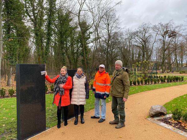 Bürgermeisterin Steffi Syska zeigt exemplarisch eine Platte, wie  man sie an der neuen Stele befestigen kann. Neben ihr Kathleen  Deutschbein, Thomas Eisel und Thomas Tschitschmann.