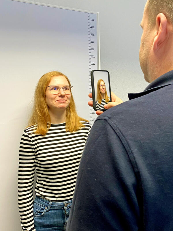 Ein Mitarbeiter fotografiert die Bürgerin  und nutzt dieses Bild direkt für einen Ausweisantrag.