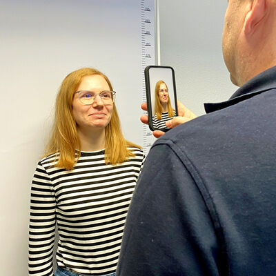 Ein Mitarbeiter fotografiert die Bürgerin  und nutzt dieses Bild direkt für einen Ausweisantrag.